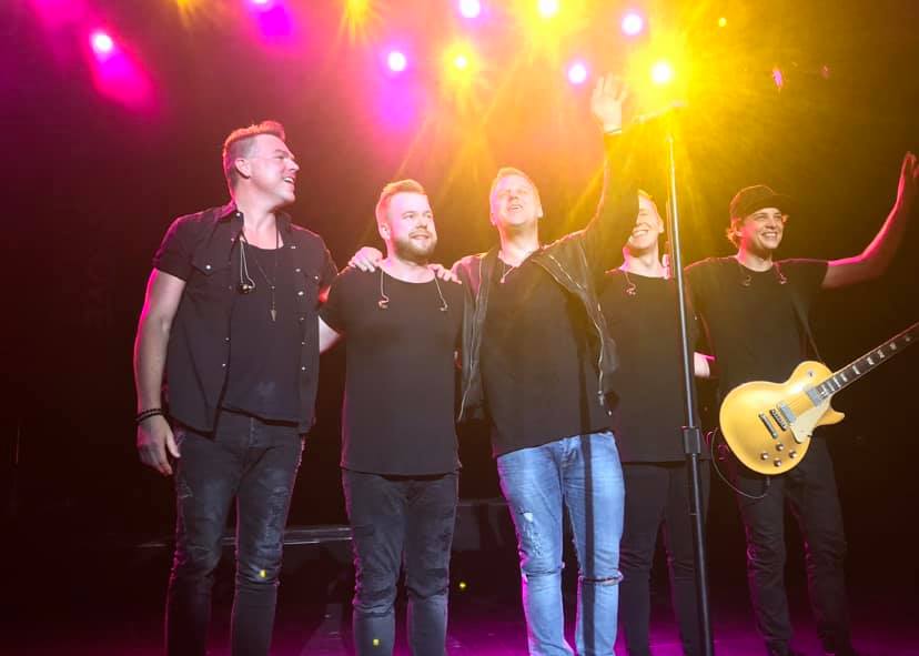 MercyMe band standing together on stage with bright colorful lights shining in the background