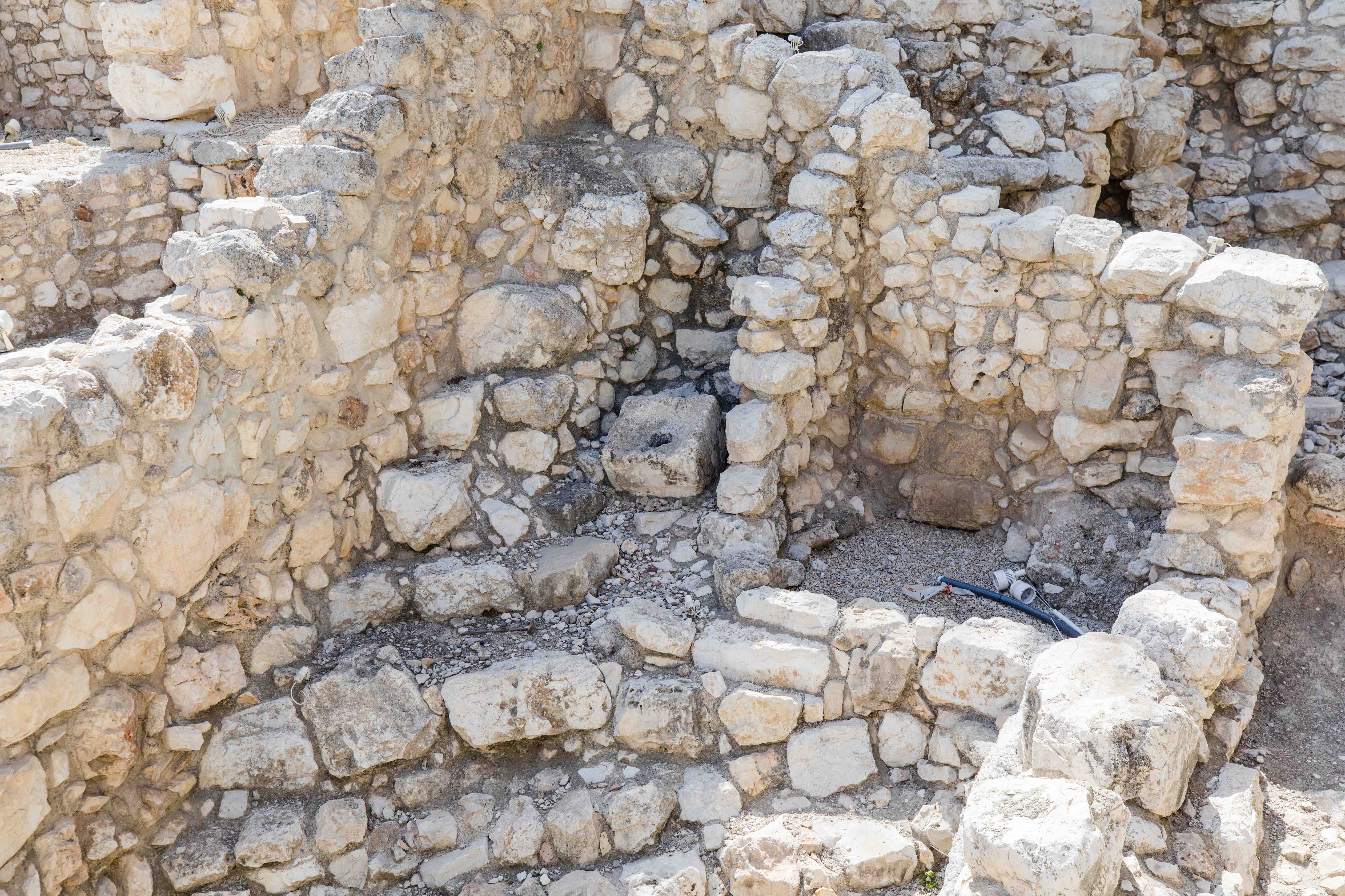 An ancient toilet carved from stone sits above an ancient septic tank in the City of David