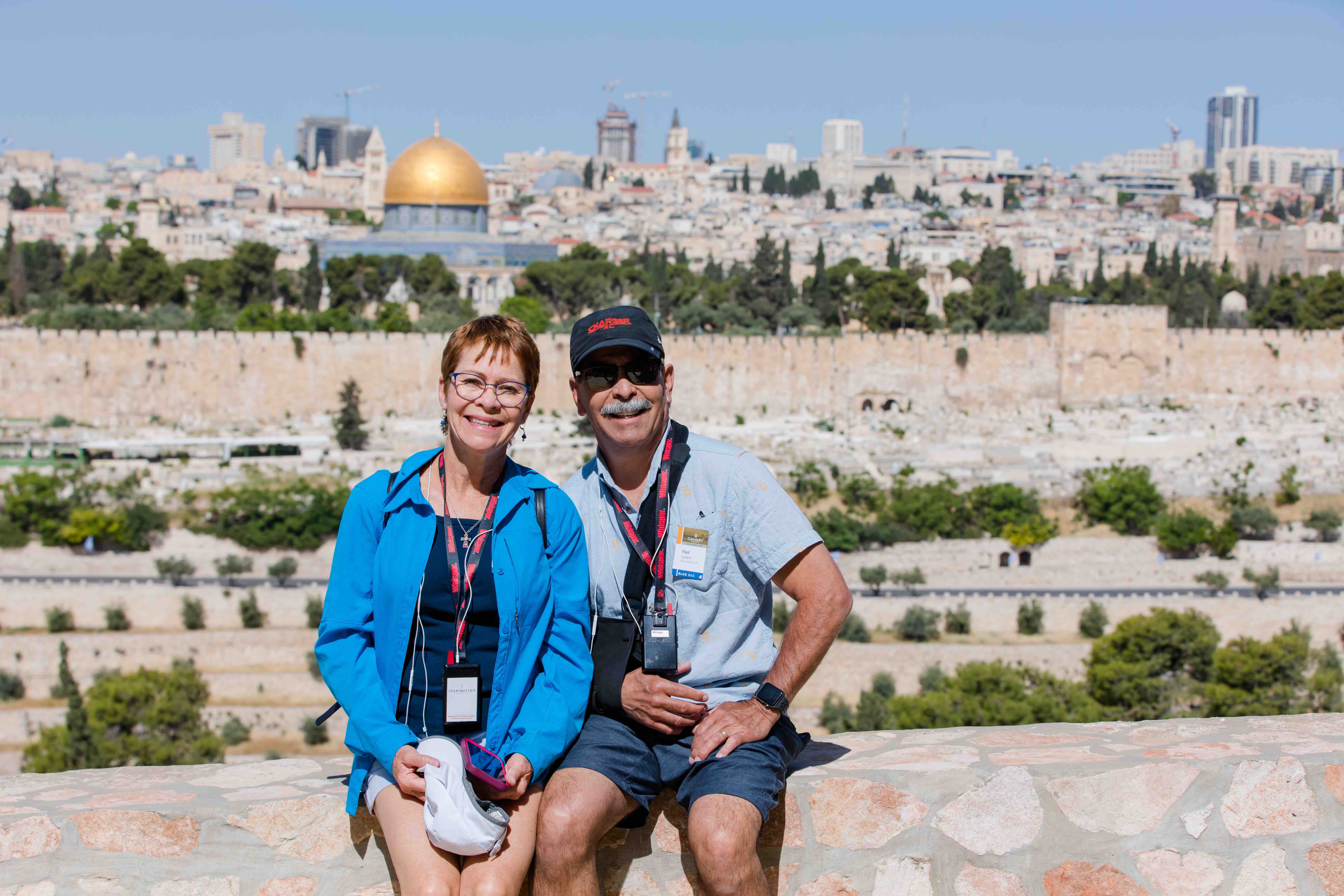 Two travelers sitting together with the skyline of Jerusalem in the background