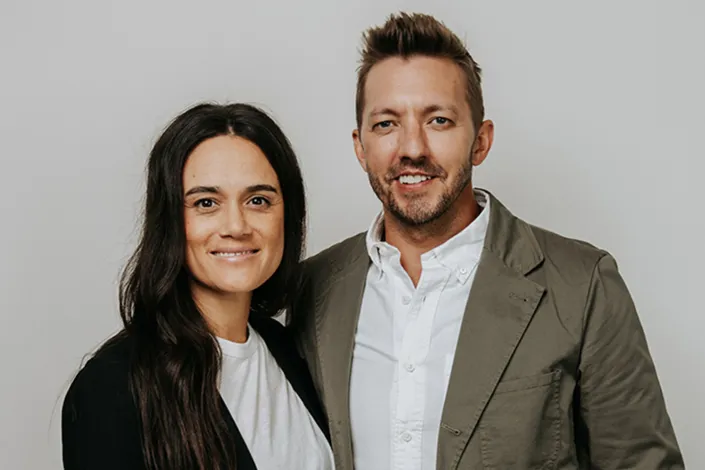 Portrait of Levi and Jennie Lusko in semiprofessional attire in front of a neutral background.
