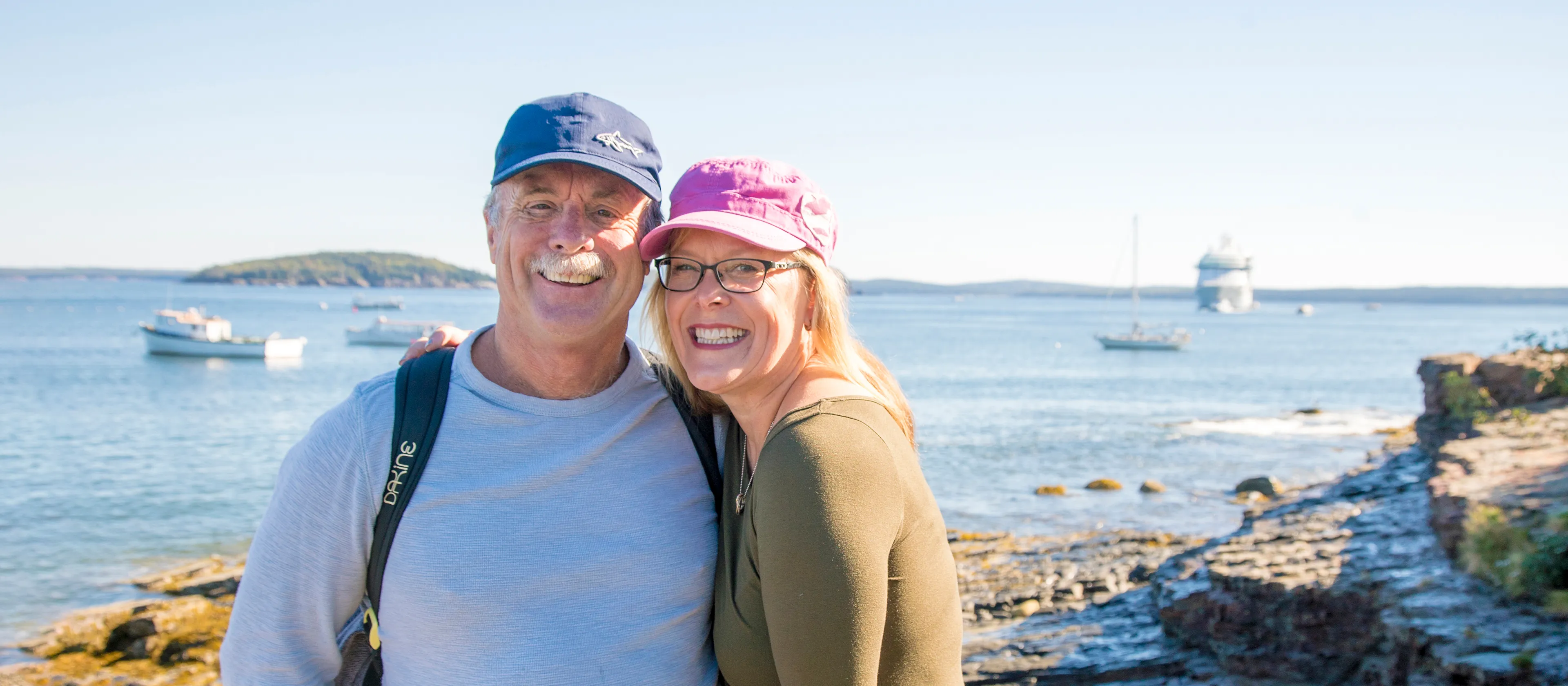 A couple standing together with the ocean in the background