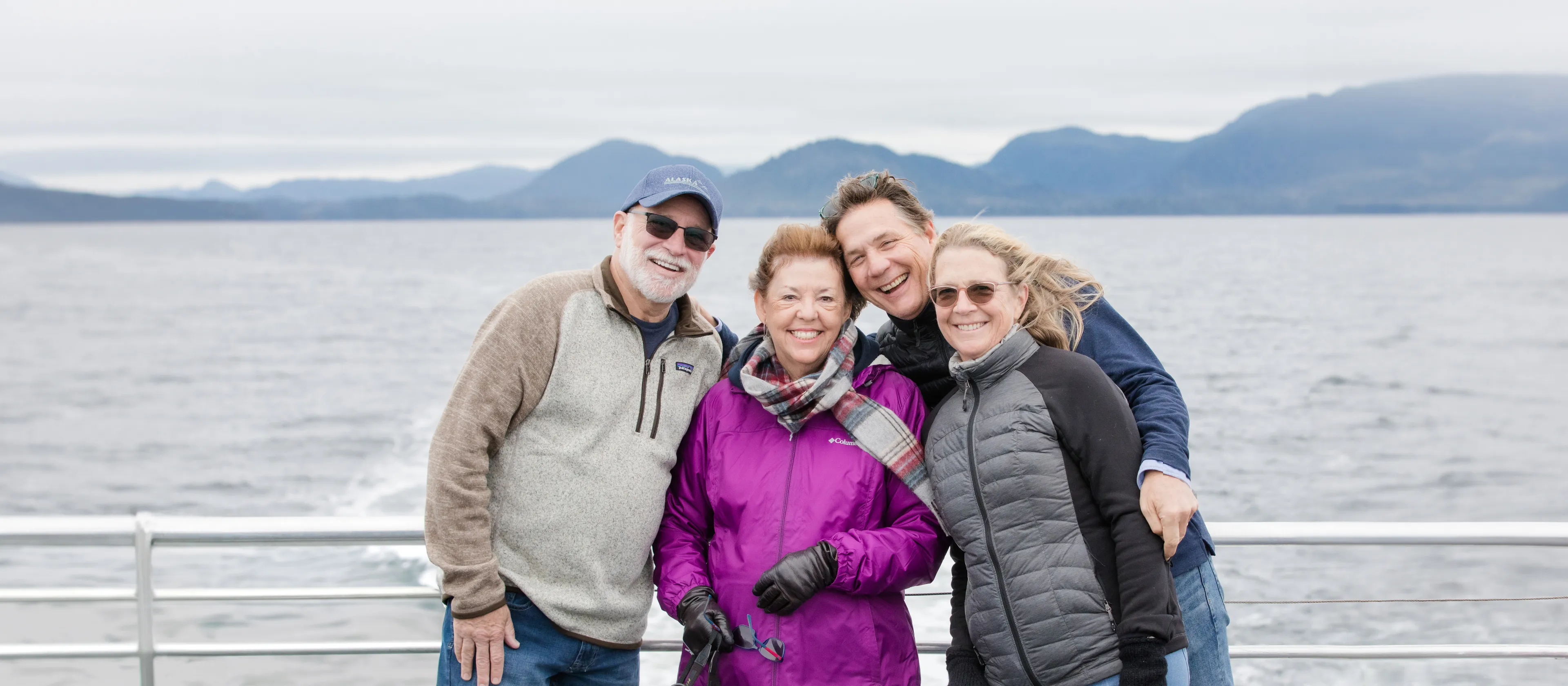 Four travelers standing together on the deck of a ship