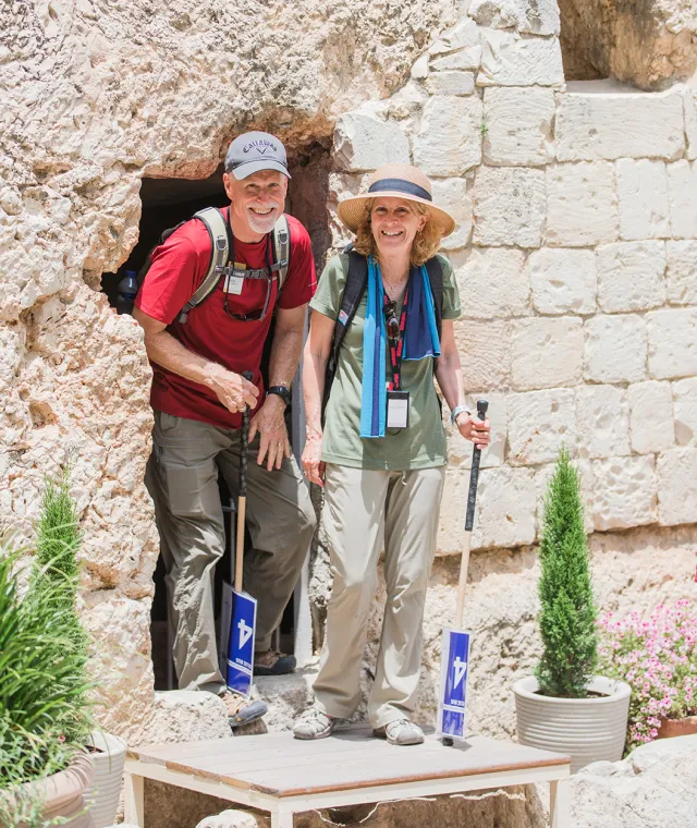 A smiling couple standing at the entrance to the Garden Tomb in Israel