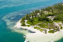 Aerial view of a sandy island tip with turquoise waters and anchored boats, Cayman Islands