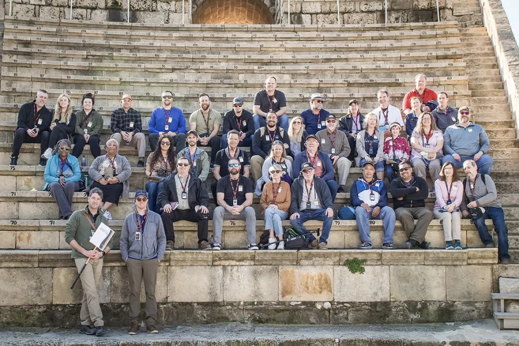 Tour guide and travelers sitting on steps in Israel