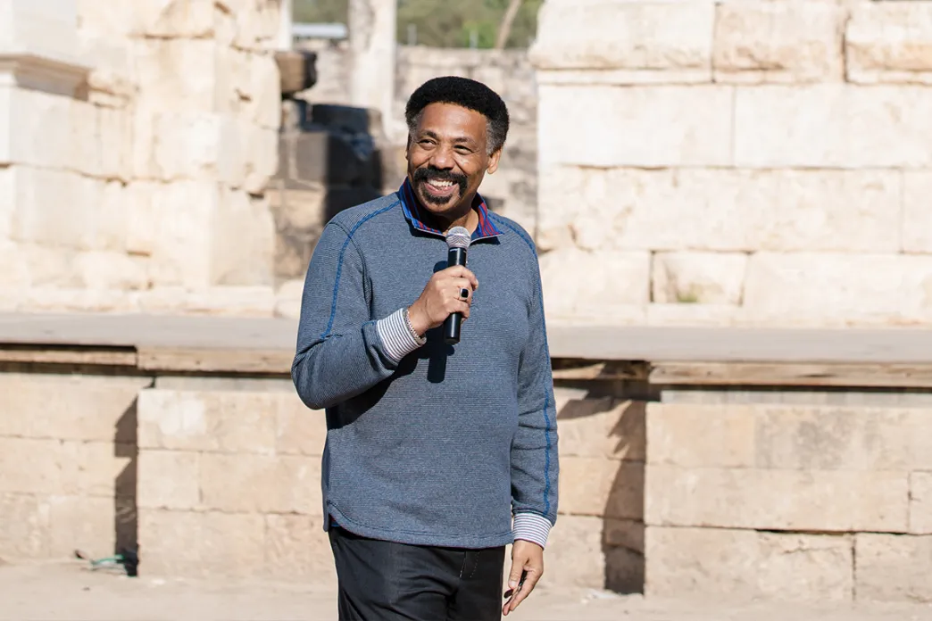 Tony Evans smiling and holding a microphone