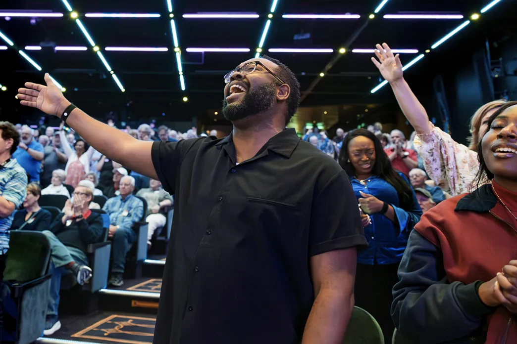 Man singing with one arm raised and eyes closed