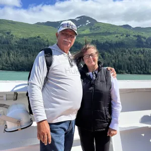 Smiling couple with the water and mountains in the background