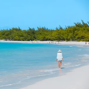 Woman walking in the water along the beach